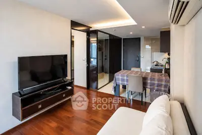 Modern living room with sleek furniture and open kitchen layout in a stylish apartment.
