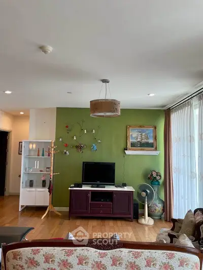 Charming living room with green accent wall and cozy seating area