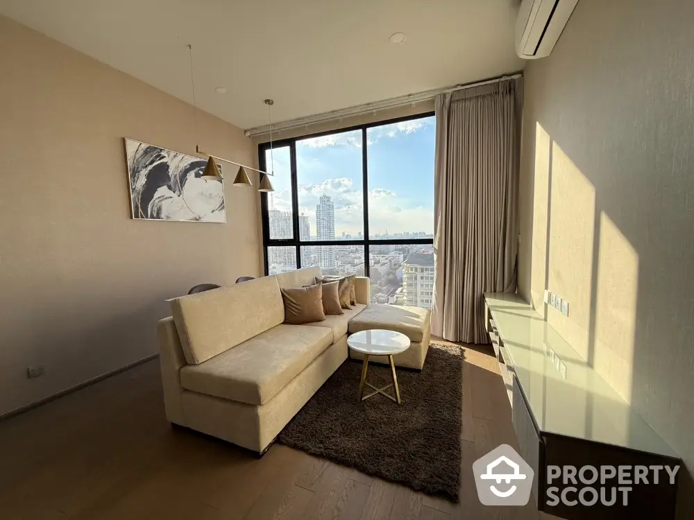 Modern living room with large window and city view, featuring cozy sofa and elegant decor.