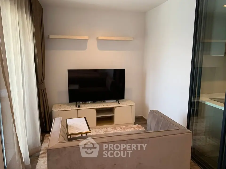 Cozy living room with modern TV setup and plush sofa in a stylish apartment.