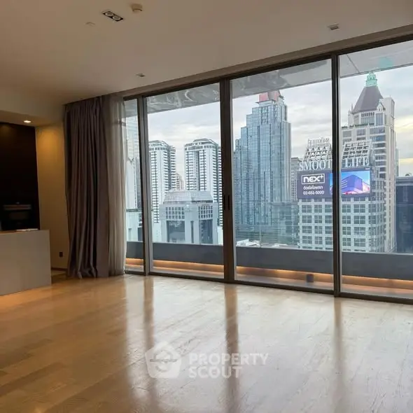 Spacious living room with floor-to-ceiling windows offering stunning city skyline views.