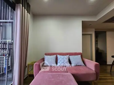 Cozy living room with pink sofa and stylish cushions, perfect for relaxation.