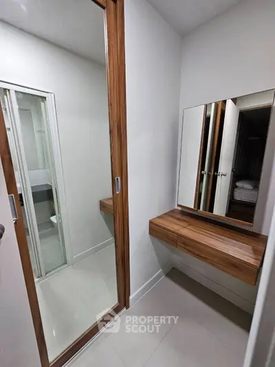 Modern bathroom with sleek wooden accents and mirrored closet doors