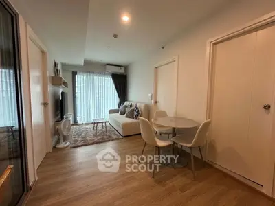 Modern living room with cozy seating and dining area, featuring stylish decor and natural light.