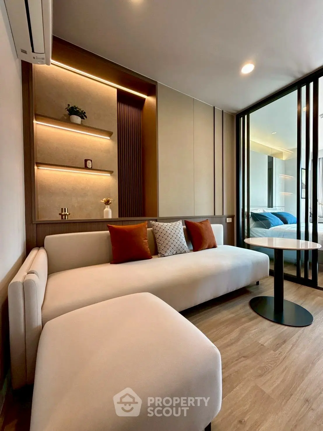 Modern living room with stylish decor and cozy seating area, featuring elegant lighting and wooden accents.