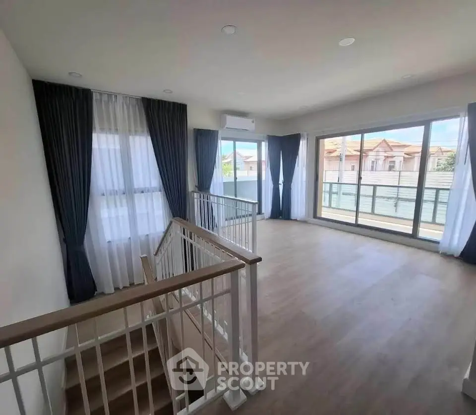 Spacious living room with large windows and balcony access, perfect for natural light lovers.