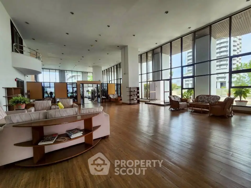 Spacious modern living room with large windows and elegant wooden flooring