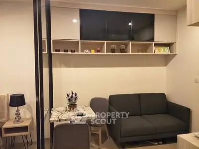 Cozy living room with modern sofa and stylish decor in a compact apartment setting.