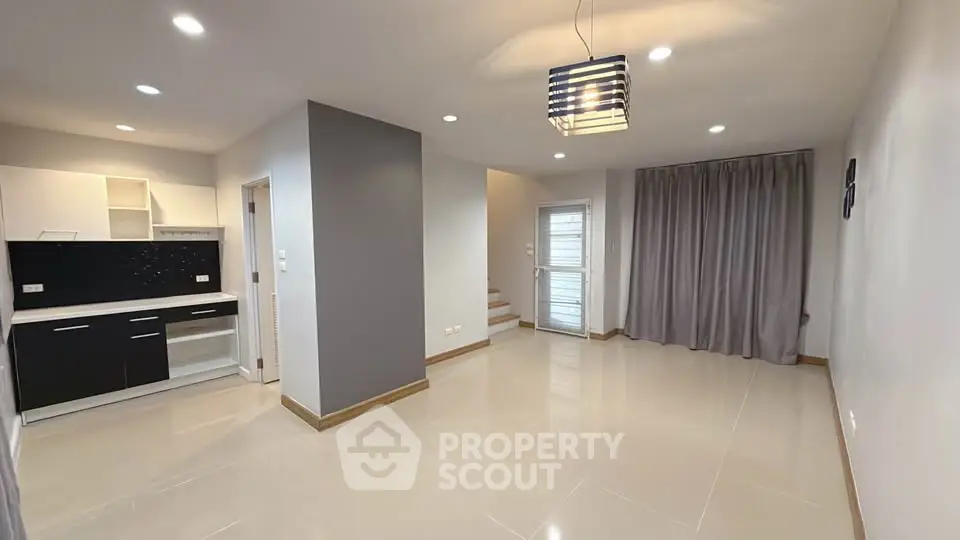 Modern open-plan living area with sleek kitchen and stylish lighting
