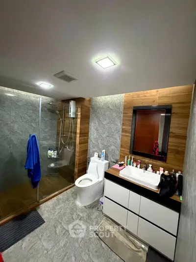 Modern bathroom with sleek design, featuring a glass shower enclosure and stylish vanity.