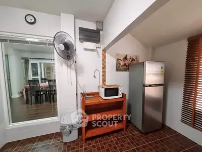Charming kitchen corner with microwave and fridge, perfect for cozy home cooking.