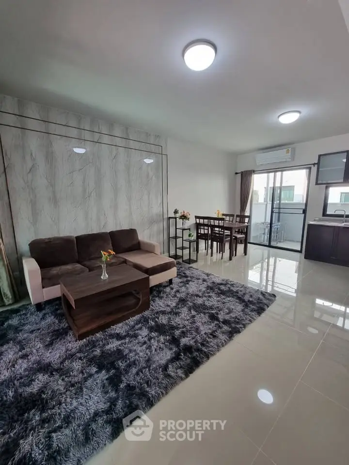 Spacious modern living room with plush carpet and dining area, perfect for entertaining.