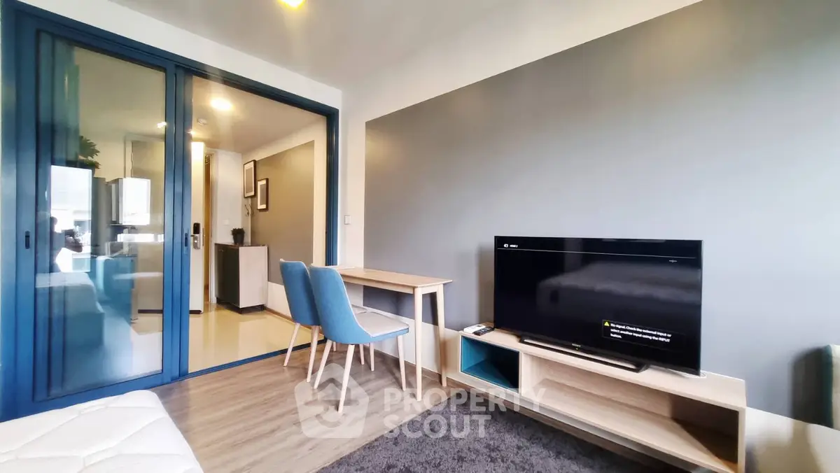 Modern living room with sleek furniture and TV, featuring a stylish open layout and contemporary design.