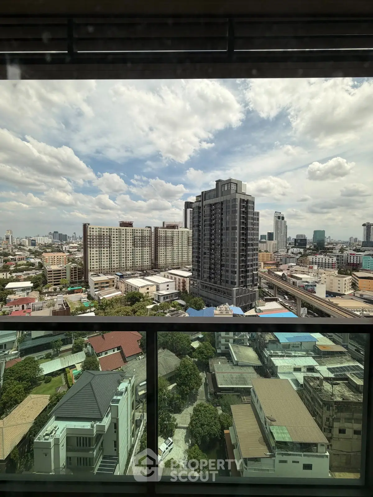 Stunning cityscape view from high-rise building balcony, showcasing urban skyline and residential areas.