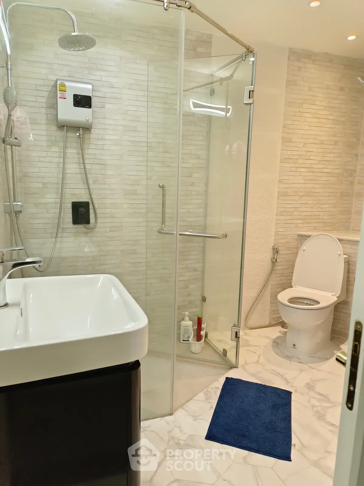 Modern bathroom with glass shower, sleek sink, and elegant tile design.