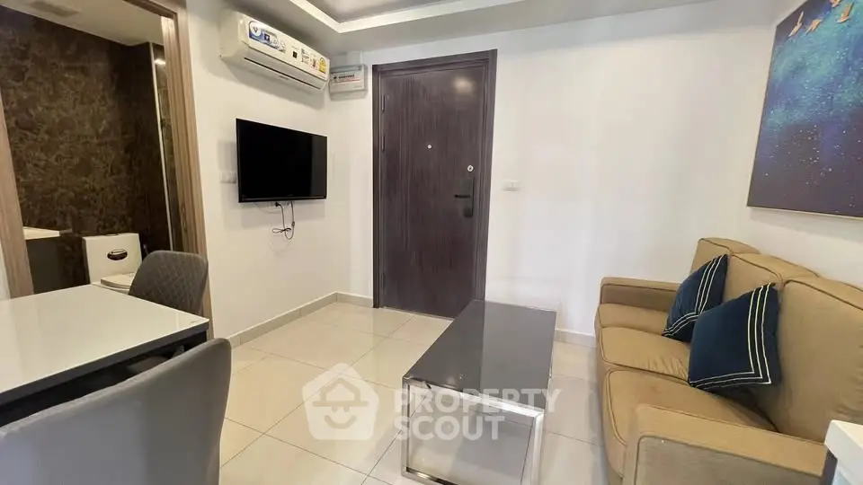 Modern living room with sleek furniture and wall-mounted TV in a cozy apartment setting.