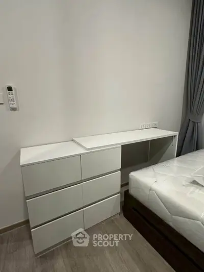 Modern bedroom with sleek white furniture and cozy ambiance