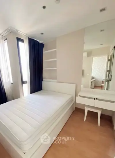 Modern bedroom with large windows and sleek furniture in a stylish apartment.