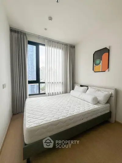 Modern bedroom with large window and city view, featuring minimalist decor and natural light.