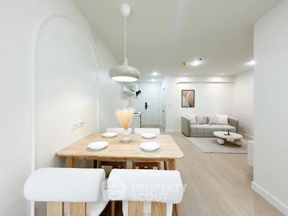 Modern open-plan living and dining area with minimalist decor and neutral tones.