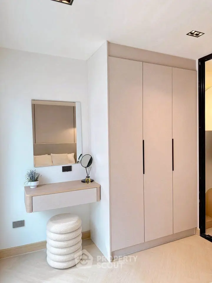 Modern bedroom with sleek wardrobe and stylish vanity area.