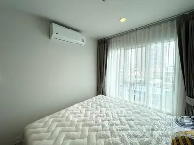 Bright bedroom with large window and air conditioning in modern apartment
