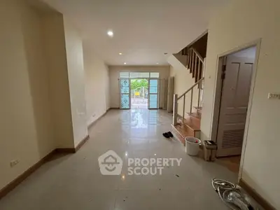Spacious unfurnished living room with staircase and large windows