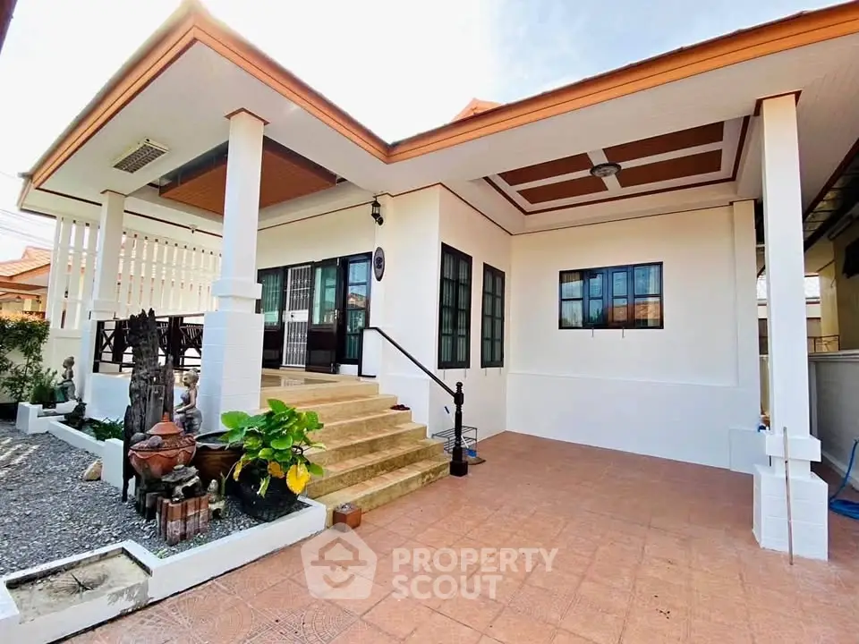 Charming single-story home with inviting entrance and spacious outdoor area, perfect for family living.