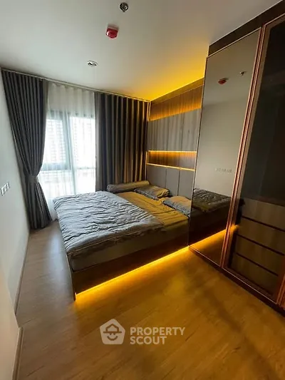Modern bedroom with ambient lighting and large mirrored wardrobe
