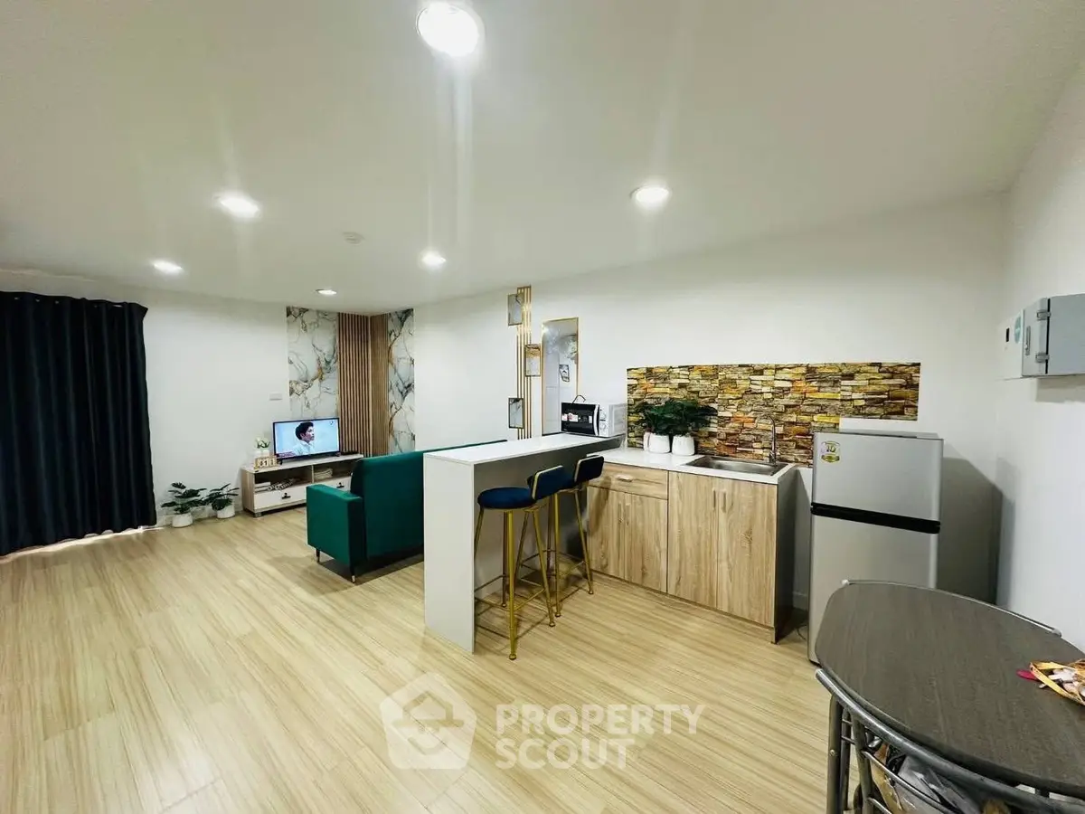 Modern open-layout living room with stylish kitchen and cozy seating area