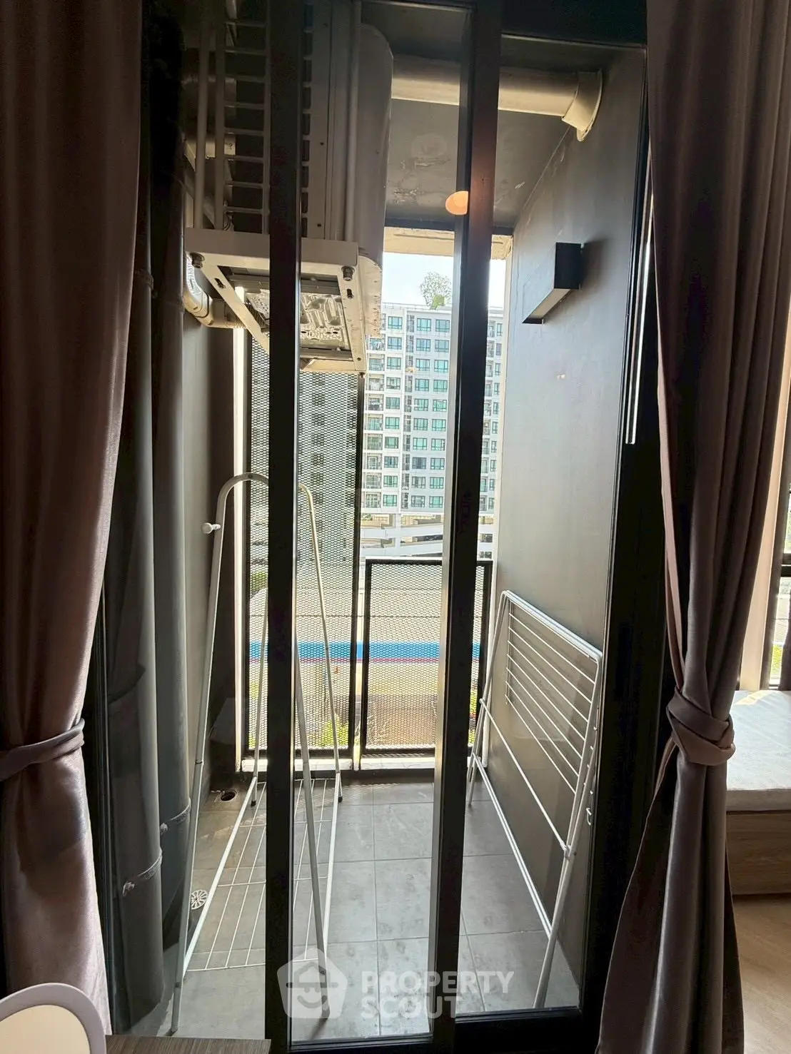 Modern apartment balcony with city view and laundry drying rack