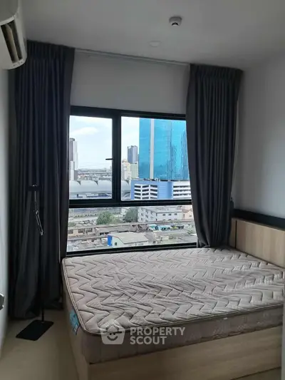 Modern bedroom with city view and large window, featuring a comfortable bed and stylish curtains.