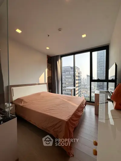 Modern bedroom with city view, large windows, and stylish decor in a high-rise apartment.