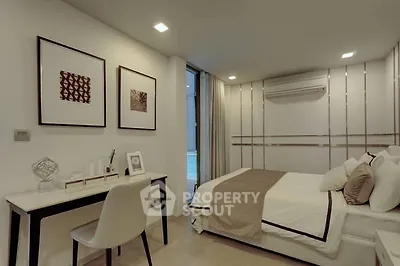 Modern bedroom with stylish decor and workspace, featuring a comfortable bed and elegant wall art.