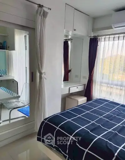 Modern bedroom with stylish decor and large window offering natural light