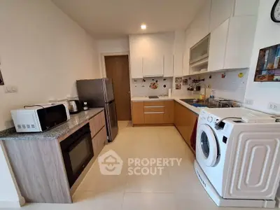 Modern kitchen with sleek appliances and ample storage in a stylish apartment.