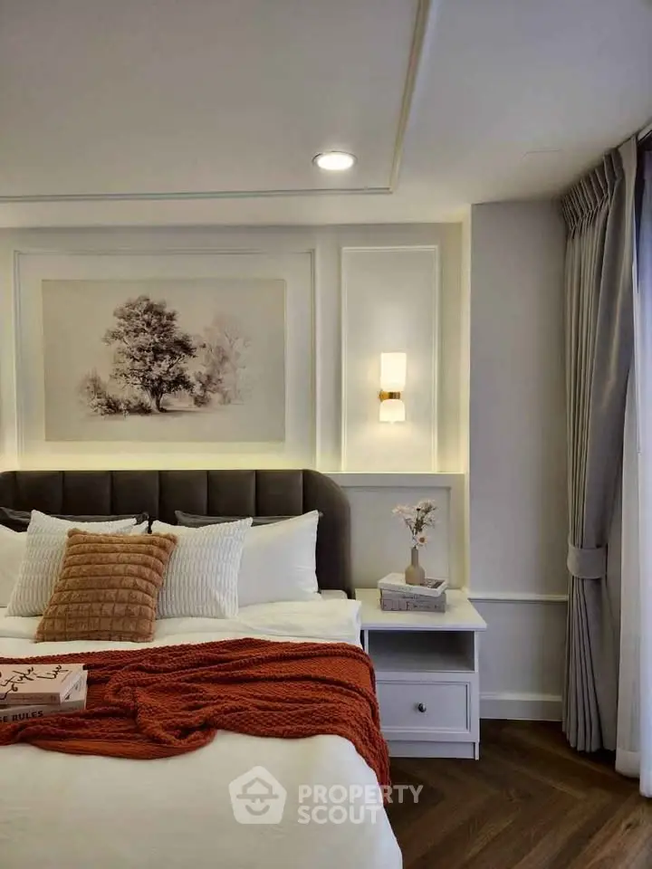 Elegant bedroom with cozy decor and natural light, featuring a stylish headboard and modern lighting.