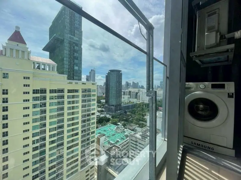 Stunning city view from high-rise balcony with washing machine setup.