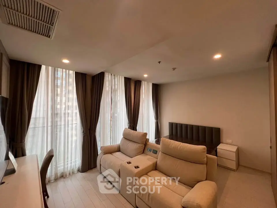 Modern living room with plush seating and floor-to-ceiling windows in a stylish apartment.