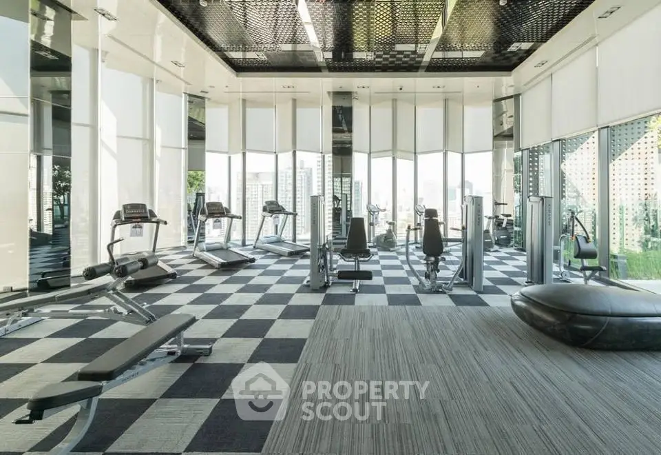 Luxurious high-rise gym with panoramic city views and modern fitness equipment.