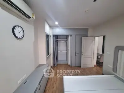 Spacious bedroom with modern design, featuring a built-in closet and air conditioning.