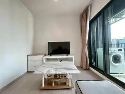 Modern living room with TV, marble table, and washing machine on balcony.