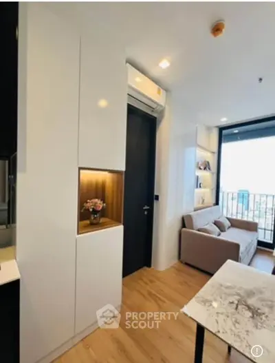 Modern living room with sleek design and balcony view in a stylish apartment.