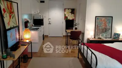 Charming studio apartment with modern decor and cozy ambiance, featuring a compact kitchen and stylish furnishings.