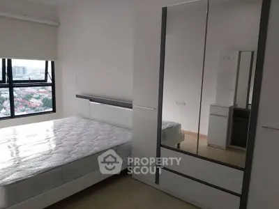 Modern bedroom with large window and mirrored wardrobe offering city views.