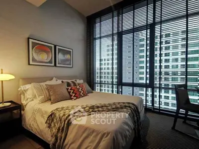 Modern bedroom with large windows offering stunning city views in a high-rise apartment.