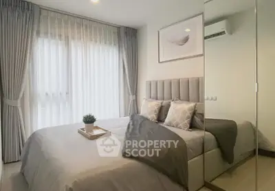 Elegant bedroom with modern decor and natural light, featuring plush bedding and stylish curtains.
