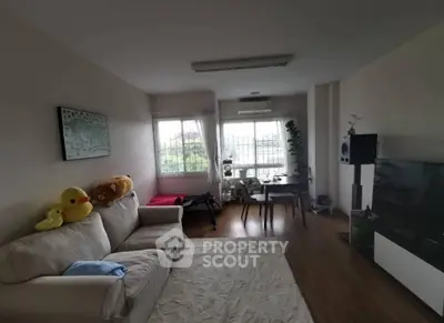 Cozy living room with plush sofa and large window offering natural light
