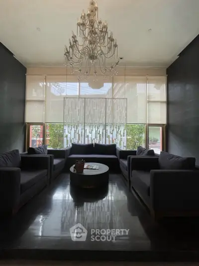 Elegant living room with chandelier and modern seating arrangement.