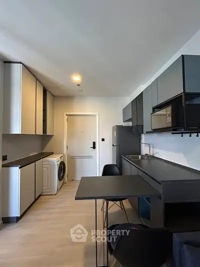 Modern kitchen with sleek cabinetry and integrated appliances in a stylish apartment.